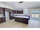 Bright kitchen featuring a marble island, dark wood cabinets, stainless steel appliances, and an open floor plan at 1131 Lupin St, Pahrump, NV 89048