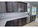 Modern kitchen with stainless steel dishwasher, dark cabinets, and stone countertops offering a beautiful view at 1131 Lupin St, Pahrump, NV 89048