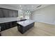 Open kitchen with a large marble island, dark wood cabinets, and stainless steel sink overlooking the yard at 1131 Lupin St, Pahrump, NV 89048