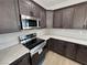 Stylish kitchen features stainless steel microwave and range, dark wood cabinets, and stone countertops at 1131 Lupin St, Pahrump, NV 89048