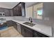 Spacious kitchen featuring a stainless steel sink with stone countertops and elegant dark wood cabinets at 1131 Lupin St, Pahrump, NV 89048
