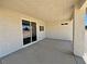An empty covered patio showcases its concrete flooring, overhead lighting, and sliding glass door to the home's interior at 1131 Lupin St, Pahrump, NV 89048