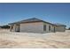 Exterior shot of house with light stucco, dark tiled roof, and covered patio in a wide open desert landscape at 1131 Lupin St, Pahrump, NV 89048