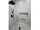 Modern shower with gray tile, hexagon tile floor and black rain shower head at 1131 Lupin St, Pahrump, NV 89048