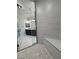 Modern shower with gray tile and black fixtures seen through glass enclosure at 1131 Lupin St, Pahrump, NV 89048