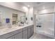 Bathroom featuring double sinks, grey cabinets, and glass enclosed shower at 1301 Miller Springs Ln # Lot 93, North Las Vegas, NV 89084