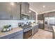 Modern kitchen with stainless steel appliances, gray cabinetry, and quartz countertops at 1301 Miller Springs Ln # Lot 93, North Las Vegas, NV 89084