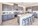 Well-equipped kitchen with stainless steel appliances, a center island, sleek gray cabinets, and tile flooring at 1301 Miller Springs Ln # Lot 93, North Las Vegas, NV 89084