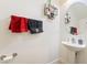 Well-lit powder room with pedestal sink, round mirror and tasteful decor for guests at 135 Manor House Ave, Las Vegas, NV 89123