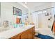 Well-lit bathroom with a large mirror, vanity, and shower-tub combination at 135 Manor House Ave, Las Vegas, NV 89123