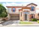 Charming two-story home featuring stucco siding, decorative shutters, and a convenient attached two-car garage at 135 Manor House Ave, Las Vegas, NV 89123