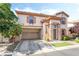 Charming two-story home featuring stucco siding, decorative shutters, and a convenient attached two-car garage at 135 Manor House Ave, Las Vegas, NV 89123