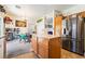 Functional kitchen featuring an island, stainless steel refrigerator, and adjacent dining area for seamless entertaining at 135 Manor House Ave, Las Vegas, NV 89123