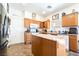 Functional kitchen featuring an island, oak cabinets, and modern appliances for convenient meal preparation at 135 Manor House Ave, Las Vegas, NV 89123