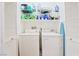 Functional laundry room with a washer, a dryer, and shelving at 135 Manor House Ave, Las Vegas, NV 89123