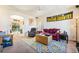 Comfortable living room featuring neutral carpeting, a ceiling fan, and an open layout with access to the backyard at 135 Manor House Ave, Las Vegas, NV 89123