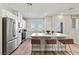 Modern kitchen with stainless steel appliances, white cabinets, an island, and three leather counter stools at 137 Harmonica Ave # Lot 19, Henderson, NV 89015