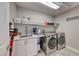 Functional laundry room equipped with modern washer/dryer, sink, countertop, and ample storage space at 1523 Great Sands St, Boulder City, NV 89005