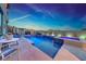 Backyard featuring a pool and jacuzzi with stylish lighting, accompanied by a table with chairs and lounge chairs at 1523 Great Sands St, Boulder City, NV 89005