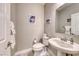 Stylish powder room featuring a pedestal sink, modern toilet, mirror and neutral color palette at 1523 Great Sands St, Boulder City, NV 89005