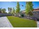 Spacious backyard featuring lush artificial turf, paved area, and several trees at 1553 Bright View Dr, Las Vegas, NV 89119