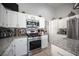 Well-appointed kitchen features stainless steel appliances, granite countertops, white cabinets, and ample storage, ideal for cooking enthusiasts at 1553 Bright View Dr, Las Vegas, NV 89119