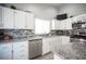 Spacious kitchen features white cabinets, stainless steel appliances, granite countertops, and tile backsplash, creating a modern culinary space at 1553 Bright View Dr, Las Vegas, NV 89119