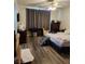 Bedroom featuring wood-look flooring, curtains, ceiling fan, and television on the wall at 1617 Stonefield St, Las Vegas, NV 89144