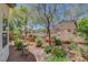 Backyard landscaping with trees, shrubs, rock features and fencing at 169 Pioneer Peak Pl, Las Vegas, NV 89138