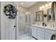 Well-lit bathroom with double sinks, white cabinets, and a glass-enclosed shower at 169 Pioneer Peak Pl, Las Vegas, NV 89138