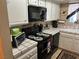 Updated kitchen with black appliances, tile countertops, and ample counter space for meal preparation at 1866 Camino Verde Ln, Las Vegas, NV 89119