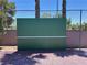 Community tennis practice wall with a green surface and brick wall on the side at 1866 Camino Verde Ln, Las Vegas, NV 89119