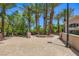 Circular driveway and landscaping featuring mature trees and a charming exterior wall at 2050 W Warm Springs Rd # 3624, Henderson, NV 89014