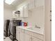 Functional laundry room features modern washer and dryer with overhead cabinets and a sink at 2050 W Warm Springs Rd # 3624, Henderson, NV 89014