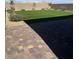 Well-kept backyard with artificial turf, a desert landscape and a brick patio at 2645 Cava Tirreni St, Henderson, NV 89044