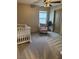 Cozy Bedroom with a white crib, soft pink rocking chair, and ambient ceiling fan lighting at 2645 Cava Tirreni St, Henderson, NV 89044
