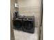Modern laundry area with front-load washer and dryer, shelf and tile floors at 2645 Cava Tirreni St, Henderson, NV 89044