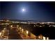 Night view of the homes with a moonlit sky and city lights in the distance at 2653 Crystal Blue St, Laughlin, NV 89029