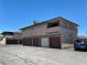 Rear exterior of an apartment with garages and vehicle parked on pavement at 2657 Kline Cir, Las Vegas, NV 89121