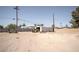 Expansive backyard featuring dirt landscaping, a storage shed, and a tractor for property maintenance at 2755 E Russell Rd, Las Vegas, NV 89120