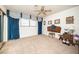 Bedroom with large windows, blue curtains, plush carpeting, a ceiling fan, and unique vintage decor at 2755 E Russell Rd, Las Vegas, NV 89120