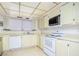 Traditional kitchen featuring cream-colored cabinets and white appliances at 2755 E Russell Rd, Las Vegas, NV 89120