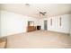 Spacious bedroom featuring a ceiling fan, beige carpet, and a glimpse into an adjacent bathroom at 2755 E Russell Rd, Las Vegas, NV 89120
