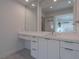 Modern bathroom featuring dual mirrors, a bright countertop and white cabinetry with sleek, minimalist hardware at 2797 Turtle Head Peak Dr, Las Vegas, NV 89135