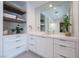 Bright bathroom featuring white cabinets, spacious countertop, vessel sink, and decorative floating shelves at 2797 Turtle Head Peak Dr, Las Vegas, NV 89135