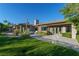Beautiful home exterior featuring a well-manicured lawn, desert landscaping, and a covered patio at 2797 Turtle Head Peak Dr, Las Vegas, NV 89135