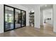 Hallway featuring glass doors, stylish built-in shelving, and wood flooring at 2797 Turtle Head Peak Dr, Las Vegas, NV 89135