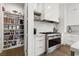 Modern kitchen featuring a large pantry, stainless steel stove, and white cabinetry at 2797 Turtle Head Peak Dr, Las Vegas, NV 89135