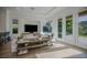 Bright and airy living area with modern decor, a large TV, and sliding glass doors for seamless indoor-outdoor flow at 2797 Turtle Head Peak Dr, Las Vegas, NV 89135