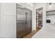 Convenient walk-in pantry with custom shelving, quartz countertops, and stainless steel refrigerator at 2797 Turtle Head Peak Dr, Las Vegas, NV 89135